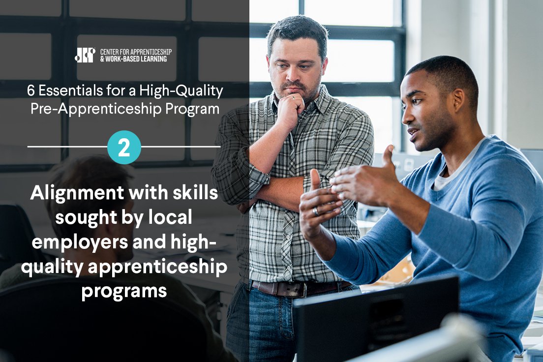 Two men discuss alignment with skills sought by local employers and high-quality apprenticeship programs in an office setting.