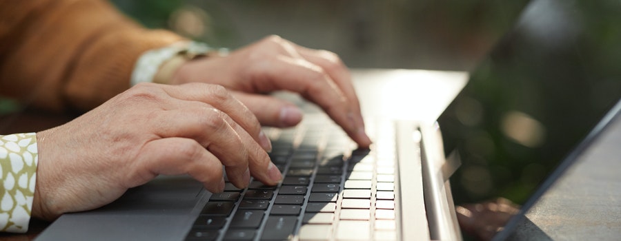 Person typing on a laptop keyboard.