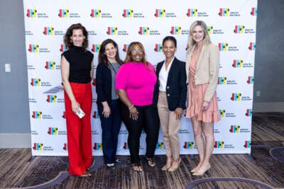 Five women standing in front of a 