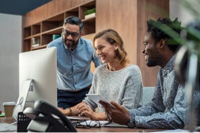People around a computer in an office