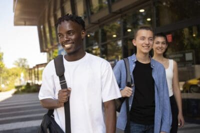 A group of young adults with backpacks walking together.