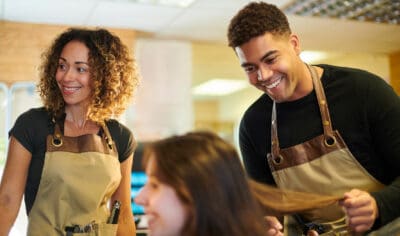 African American woman and guy standing together with aprons on
