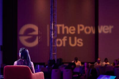 A person sits onstage in an auditorium with