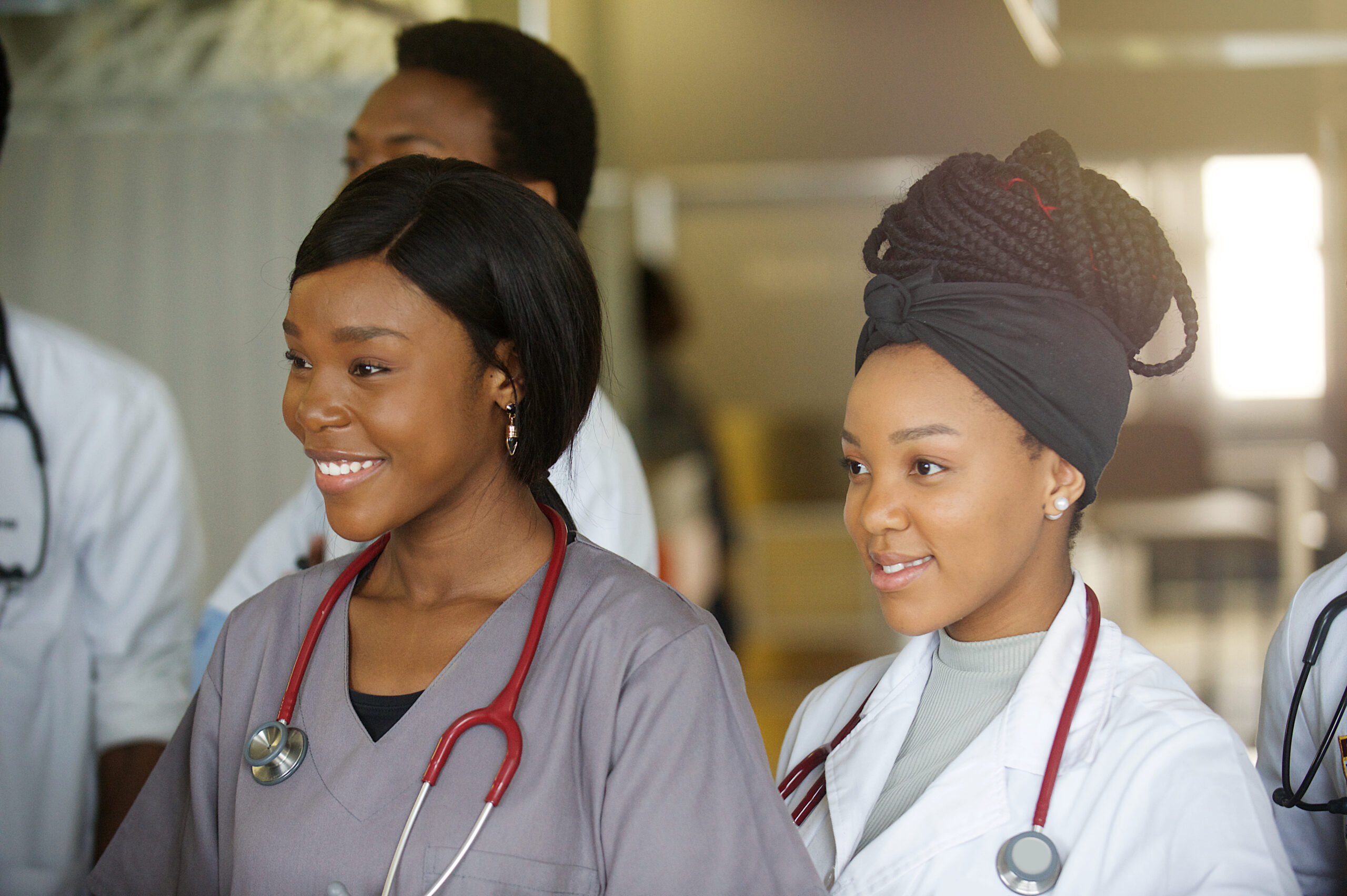A group portrait of two smiling young female student doctors in-between other young student doctors in a hospital ward in Cape Town South Africa