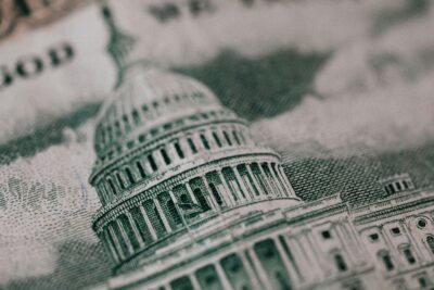 Close-up of the U.S. Capitol building as depicted on American paper currency, showing detailed engraving lines and architectural features.
