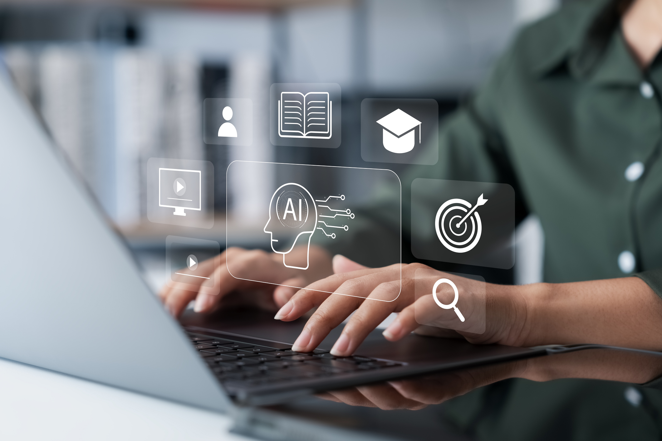 Person typing on a laptop with virtual icons for AI, online learning, book, video, user, graduation cap, and target displayed above the keyboard.